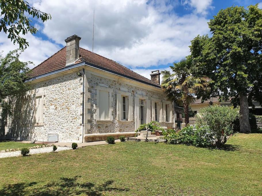 une ancienne maison en pierre avec une cour herbeuse dans l'établissement Maison de campagne - L'escale bucolique, à Villefranche-de-Longchat