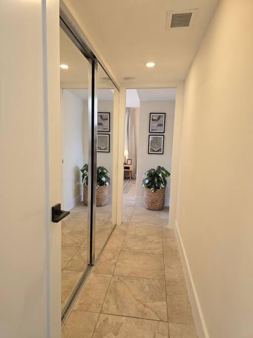 a hallway with two potted plants and a glass door at Palma Haus - Modern Villa with Pool Near the Beach in Hollywood Beach