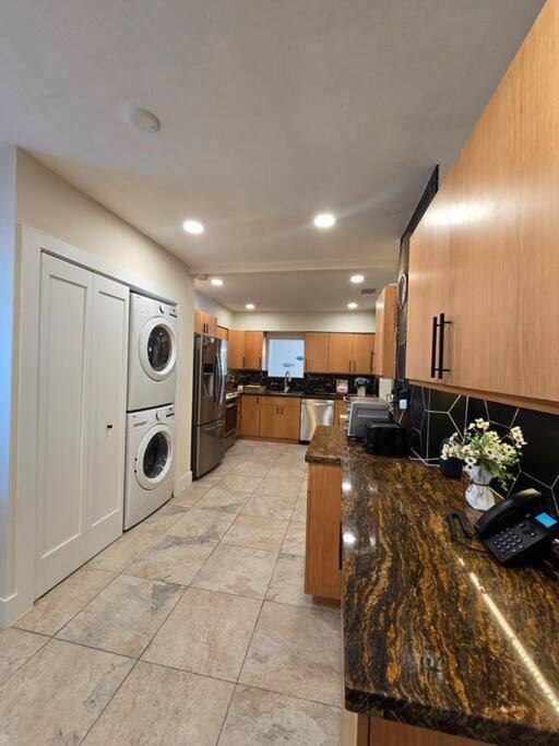 a large kitchen with a washer and dryer at Palma Haus - Modern Villa with Pool Near the Beach in Hollywood Beach