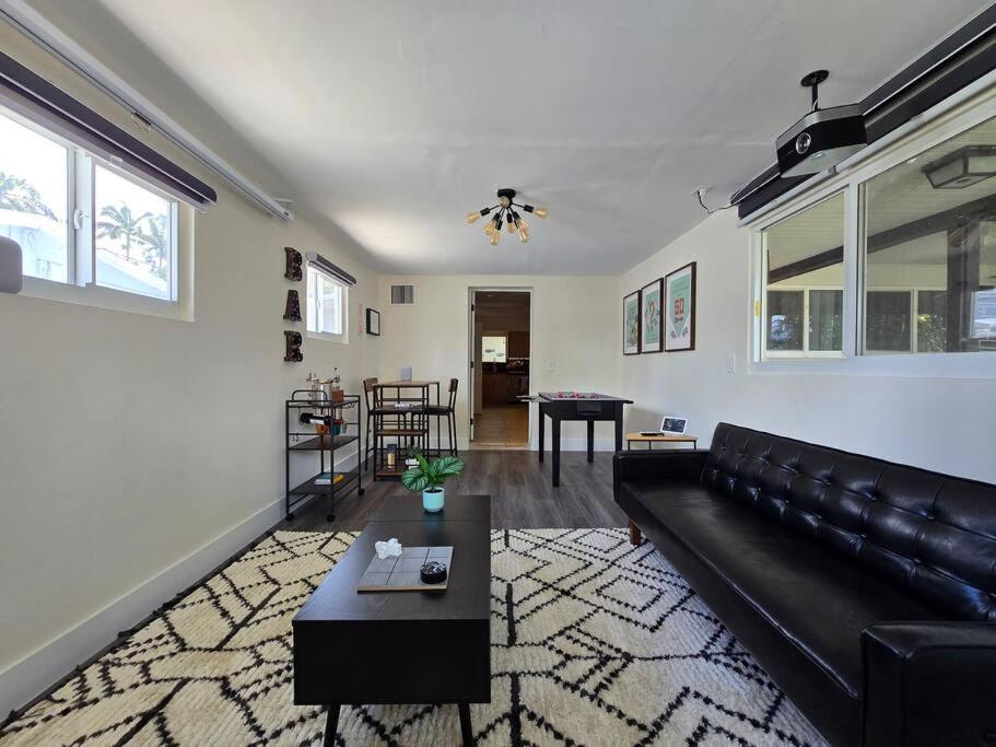a living room with a black couch and a table at Palma Haus - Modern Villa with Pool Near the Beach in Hollywood Beach