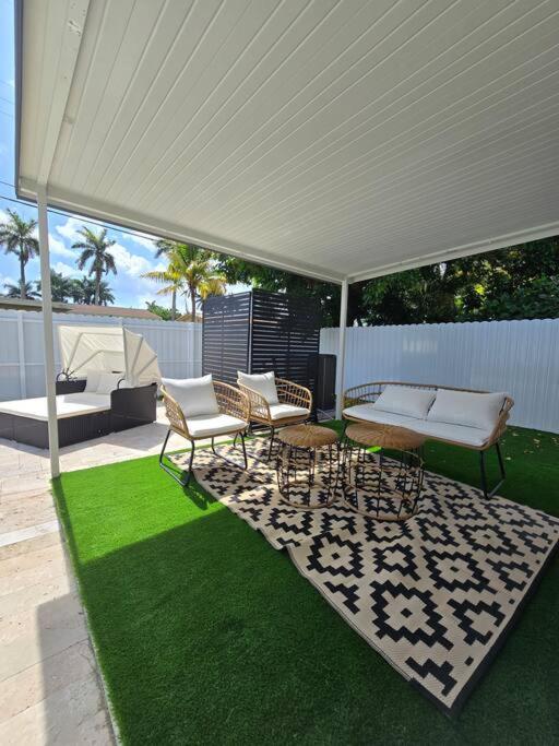 a patio with a white canopy and chairs and grass at Palma Haus - Modern Villa with Pool Near the Beach in Hollywood Beach