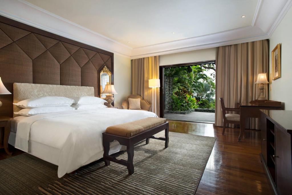 a bedroom with a large bed and a large window at Sheraton Senggigi Beach Resort in Senggigi