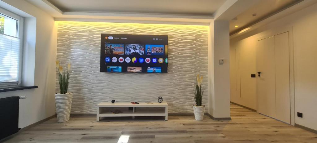 a living room with a tv on a wall at Baltivia ADULTS ONLY in Świnoujście