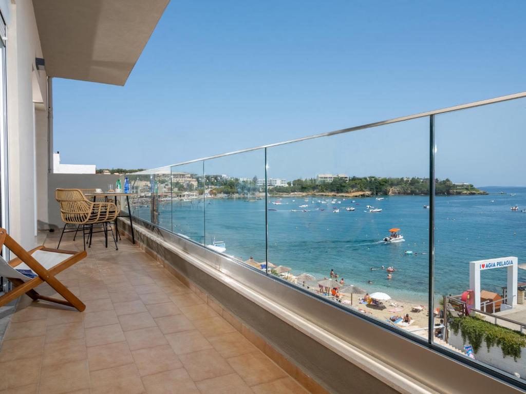 a balcony with a view of a beach and the ocean at Omnia Apartments in Agia Pelagia