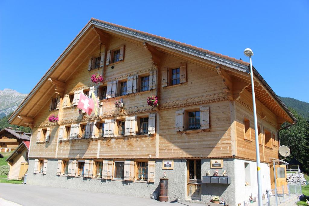 a large wooden building with flowers on the front at Les Promenades en Montagne in Chateau-d'Oex