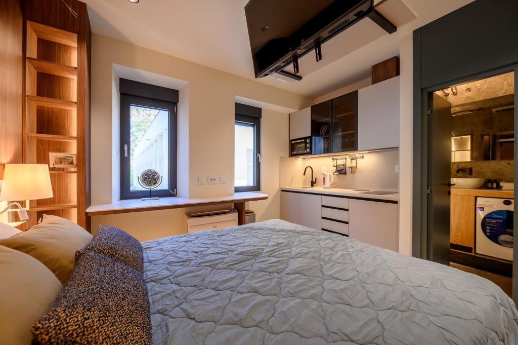 a bedroom with a large bed and a kitchen at Modular Central Studio in Kotor