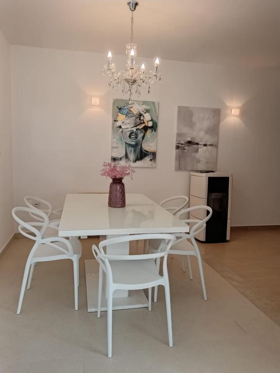 a white dining room with a white table and chairs at House Pierro in Orasac