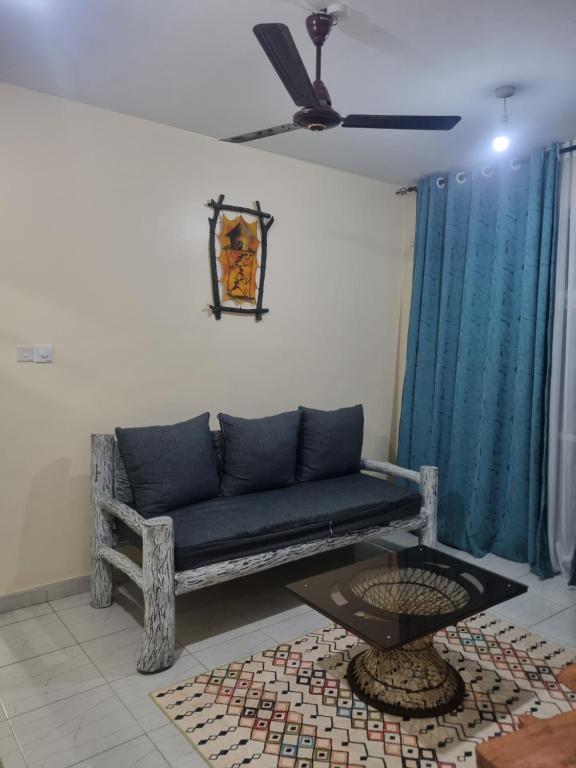 a living room with a blue couch and a table at Cessy's Apartments in Mtwapa
