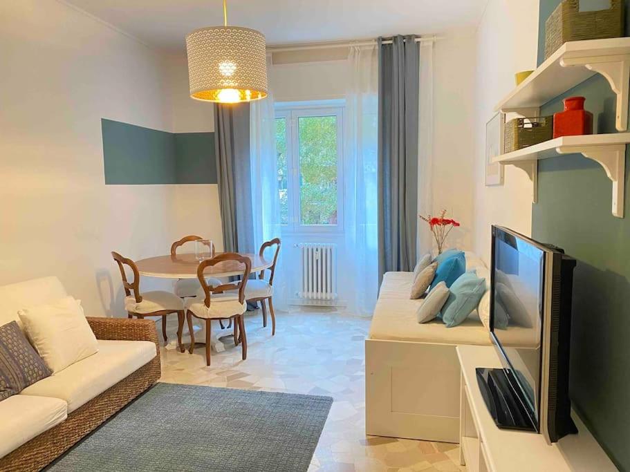 a living room with a couch and a tv and a table at Intero appartamento Rho Centro in Rho