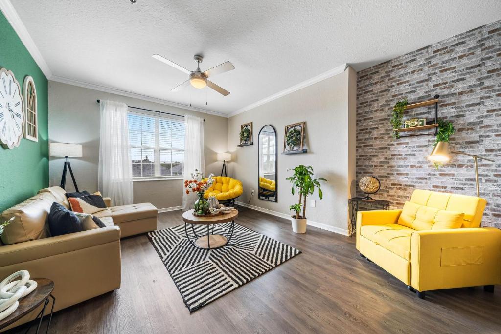 sala de estar con muebles de color amarillo y pared de ladrillo en Spacious 3br2ba W Pool Gym Near Airport #4, en Tampa