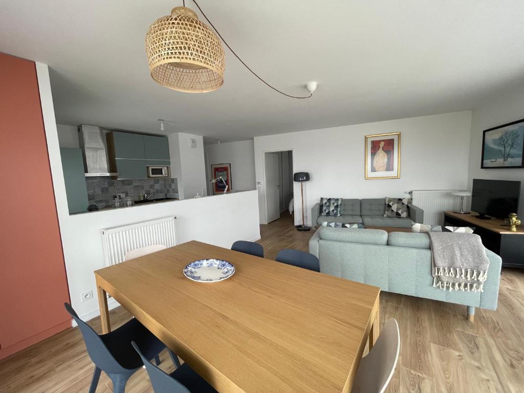 un salon avec une table et un canapé dans l'établissement Charming apartment with 3 bedrooms and terrace, à Saint-Ouen