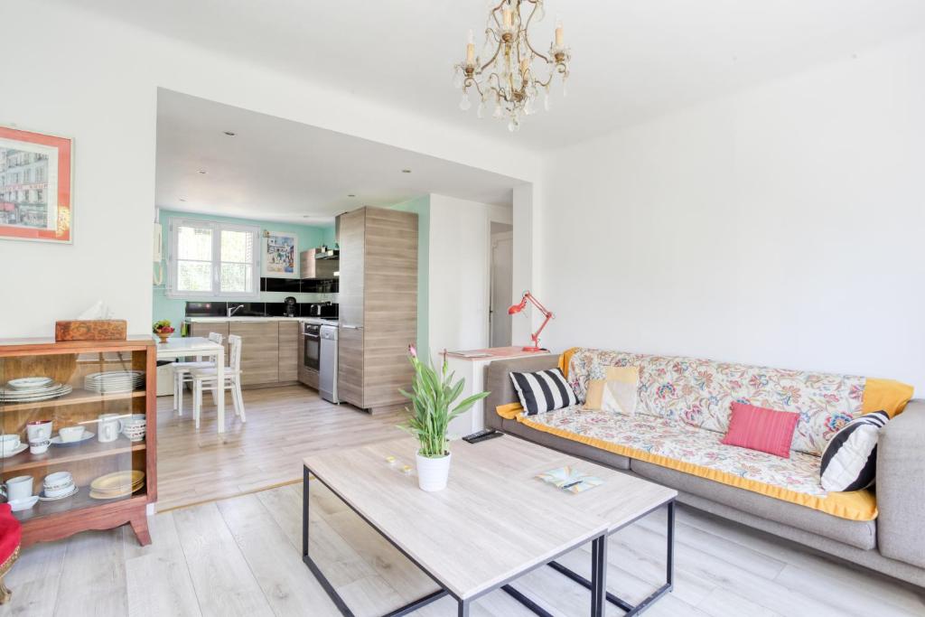 a living room with a couch and a table at Time of travel in Rueil-Malmaison