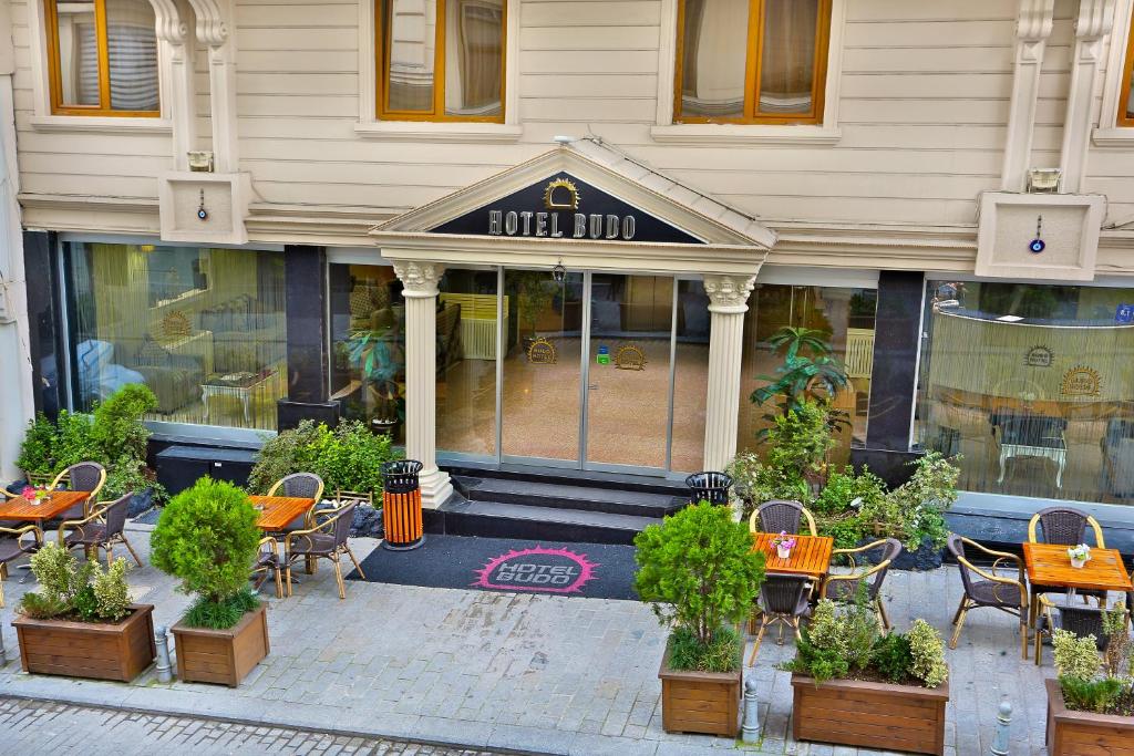 a restaurant with tables and chairs in front of a building at Budo Hotel in Istanbul