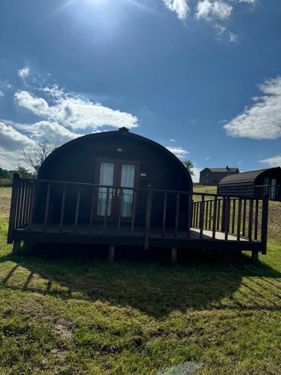 a black dome house with a bench in the grass at Lanercost lodges in Carlisle
