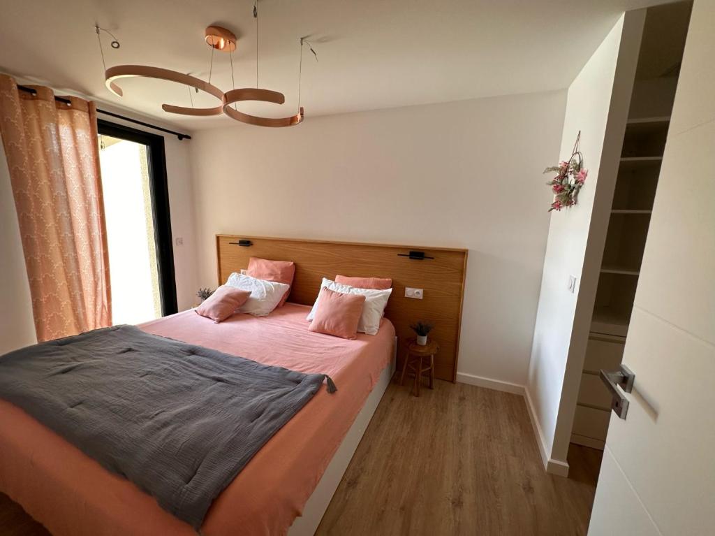 a bedroom with a bed with pink sheets and a window at Appartement ROSE, Aéroport ST EXUPERY, Groupama stadium, Eurexpo, LDLC Arena in Pusignan