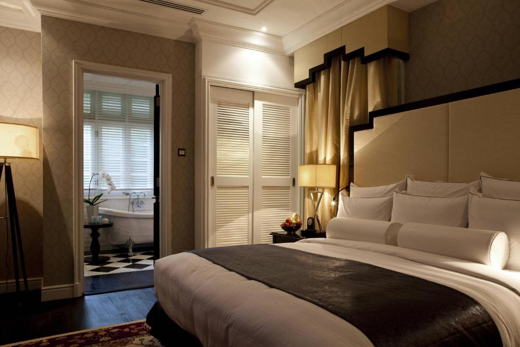 A bedroom with a large bed, shuttered doors and a visible traditional bathroom entrance.