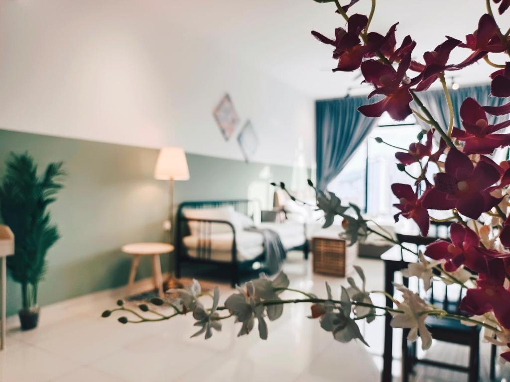 Kampong MakamにあるBeacon Executive Suites by WLの赤い花の生えたリビングルーム