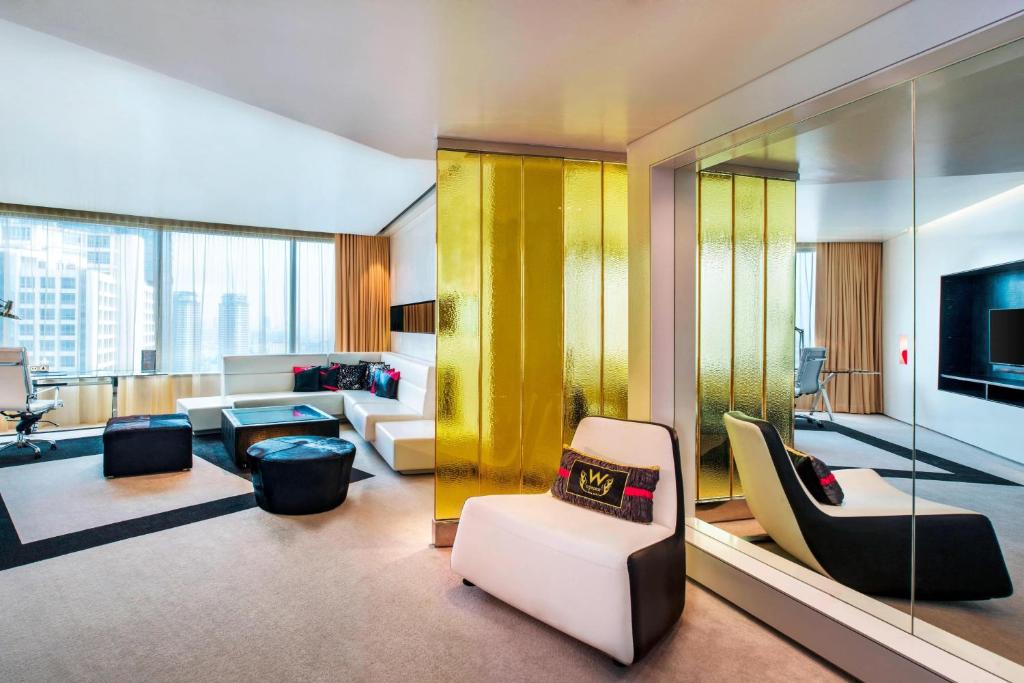 a living room filled with furniture and a yellow wall at W Bangkok Hotel in Bangkok