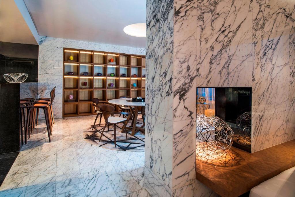 a living room with a fireplace and a table at W Bangkok Hotel in Bangkok