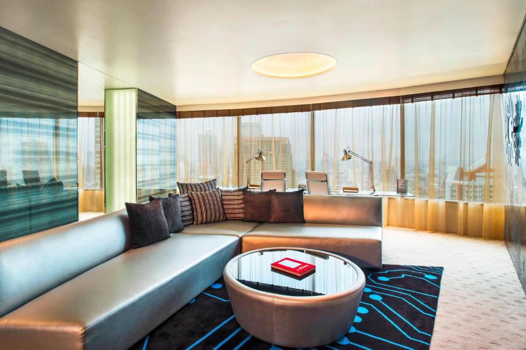 a living room with a couch and a table at W Bangkok Hotel in Bangkok