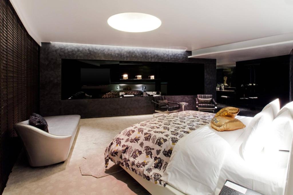 a bedroom with a large bed and a living room at W Bangkok Hotel in Bangkok