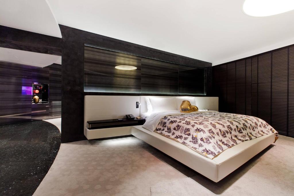 a bedroom with a large bed with a black wall at W Bangkok Hotel in Bangkok