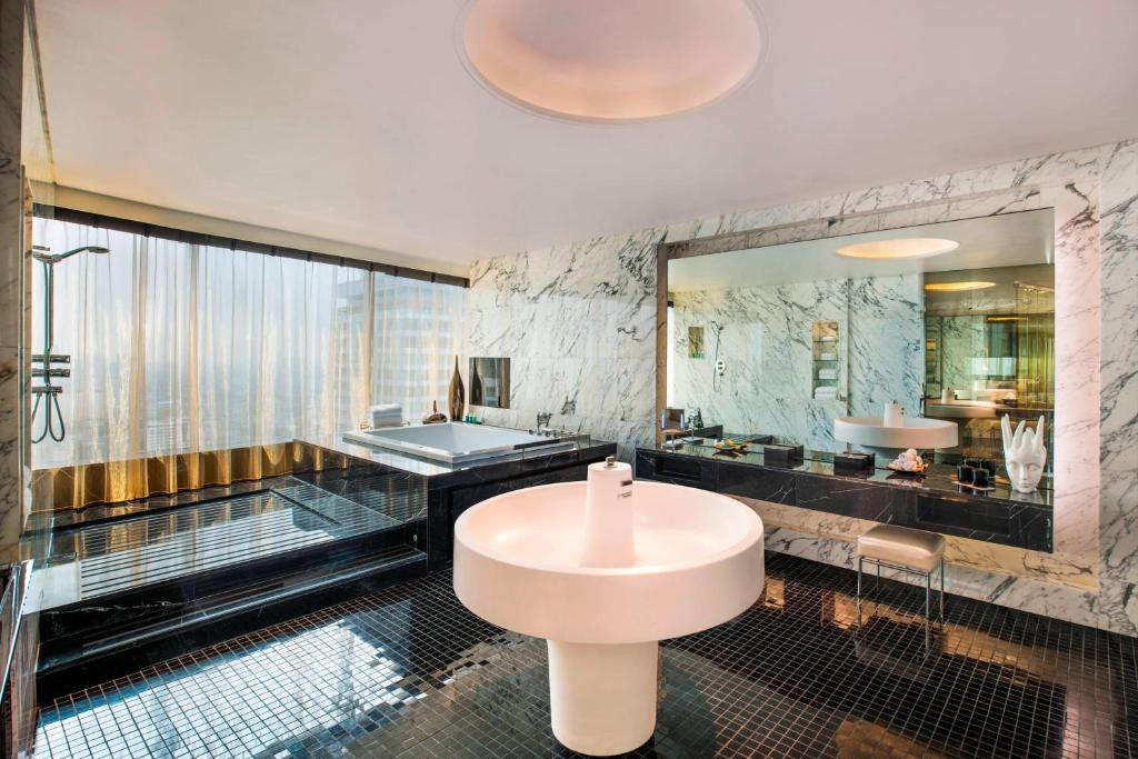 a bathroom with a sink and a bath tub at W Bangkok Hotel in Bangkok