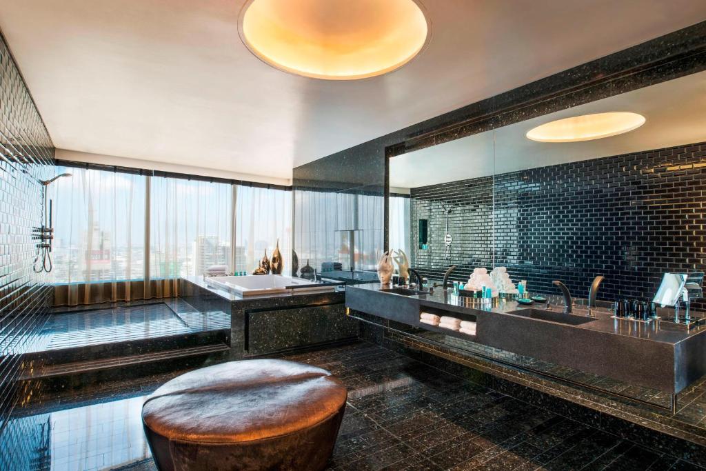 a large bathroom with a tub and a sink at W Bangkok Hotel in Bangkok