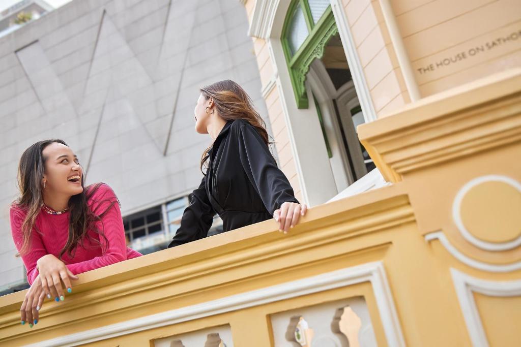 two women standing on the ledge of a building at W Bangkok Hotel in Bangkok