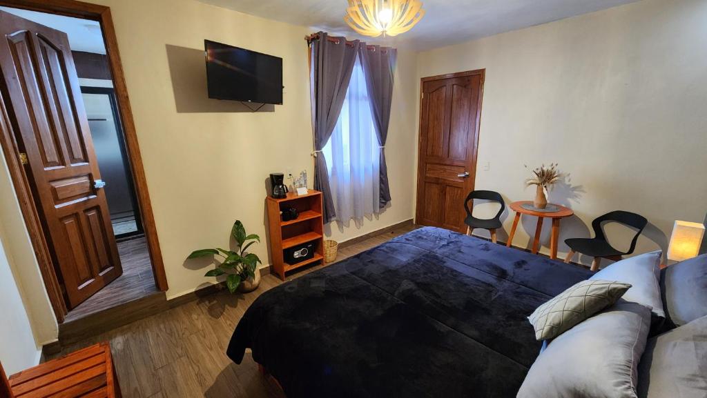 a bedroom with a bed and a table with chairs at Piedra Negra Boutique Hotel in San Cristóbal de Las Casas