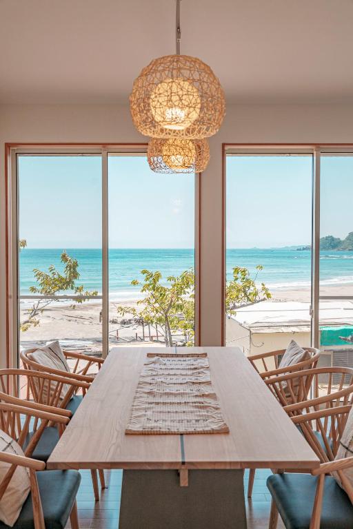 a dining table with chairs and a view of the beach at VILLA KAWAZU - Umi - in Mitaka