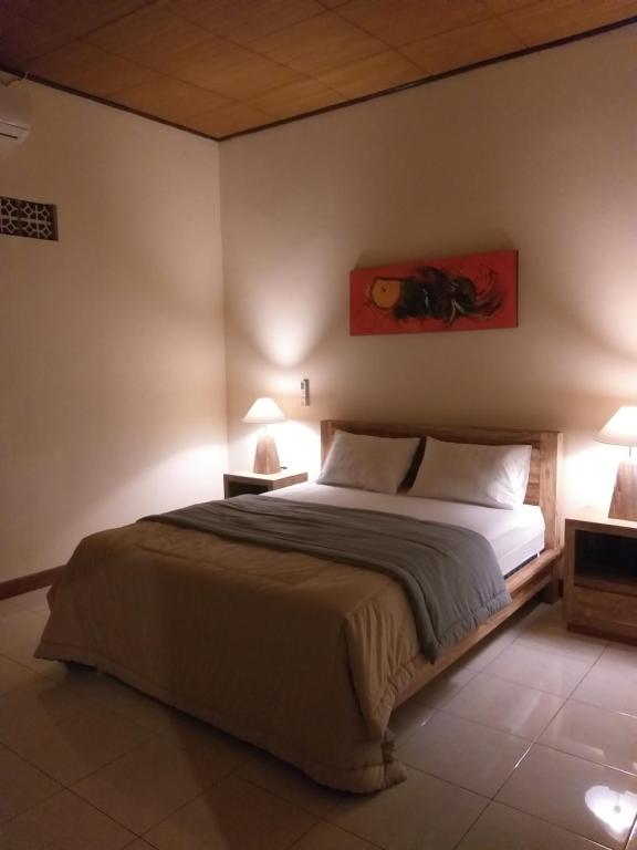 JasriにあるMama Guesthouseのベッドルーム1室(大型ベッド1台、ランプ2つ付)