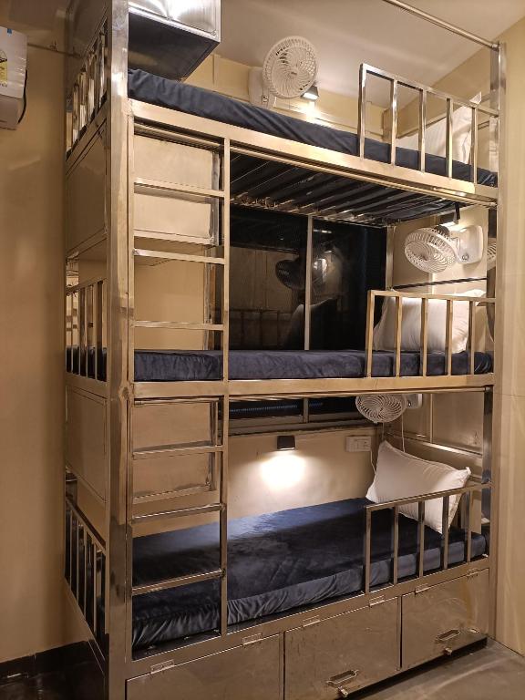 a room with bunk beds with a table and a chair at The Aroma Backpackers in Mumbai
