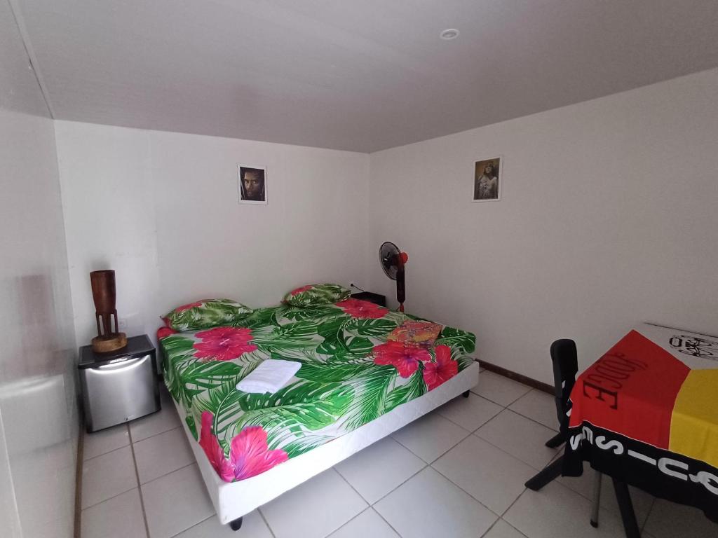 a bedroom with a large bed with a colorful bedspread at Pitake Lodge 1 in Nuku Hiva
