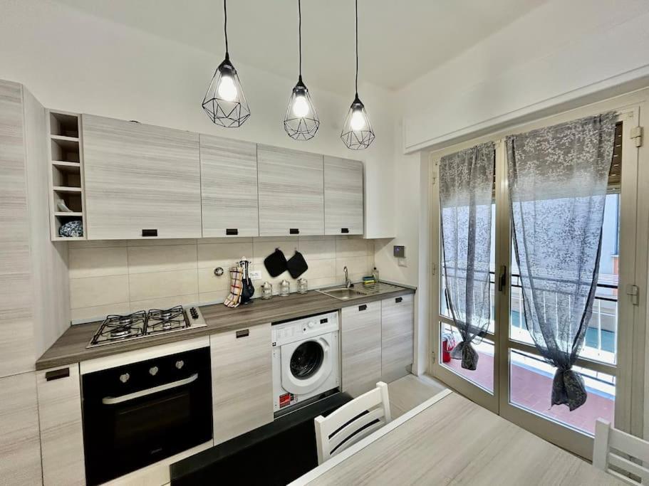 a kitchen with a stove and a washing machine in it at Casa Alessandra in Alassio