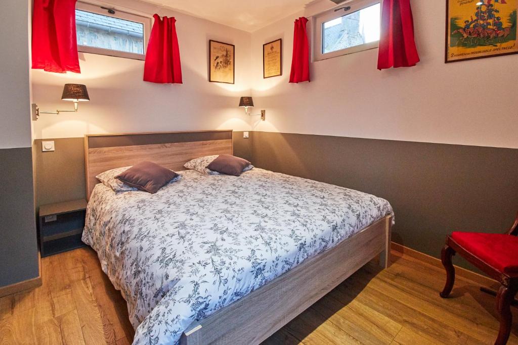 a bedroom with a bed with red curtains at La Plus Petite Maison De France in Bayeux