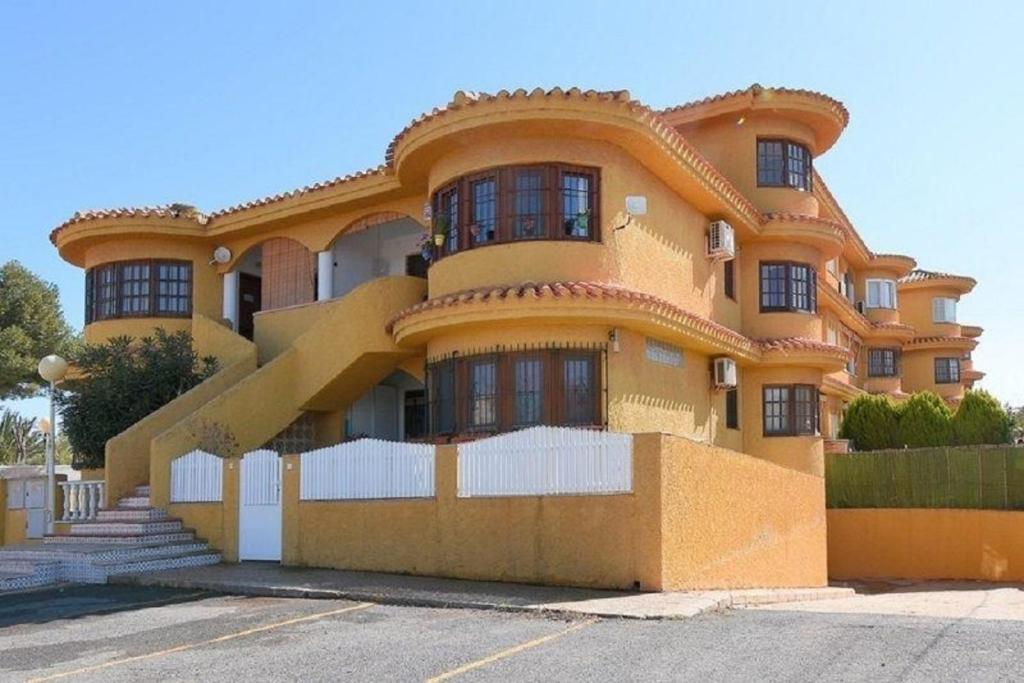 a large yellow building with a lot of windows at Wohnung in Cartagena mit Gemeinschafts Pool und Terrasse in Los Urrutias