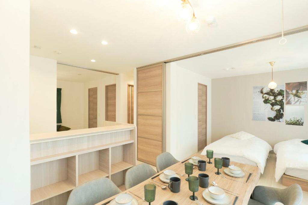 a room with a table and chairs and a bed at Gran Grace by Tranova in Tokyo