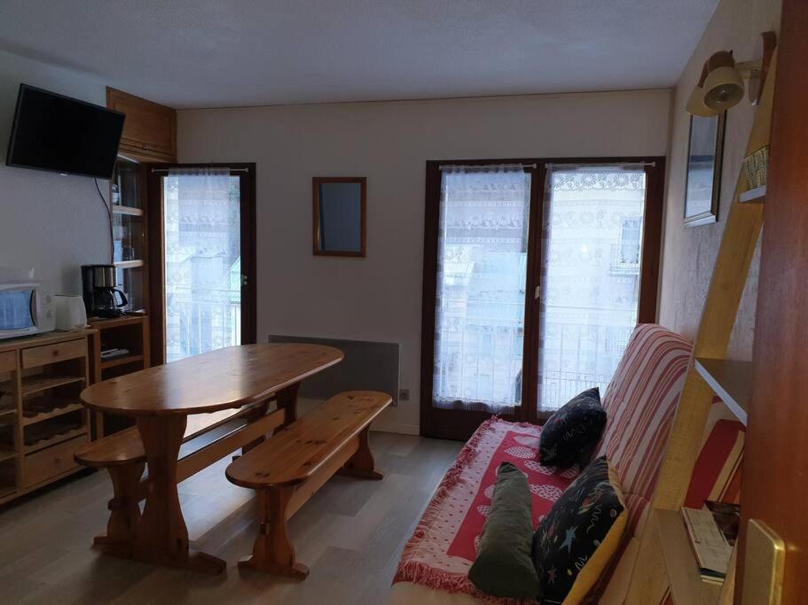 - un salon avec une table et deux chats assis sur un canapé dans l'établissement Appartement au centre de Barèges, à Barèges