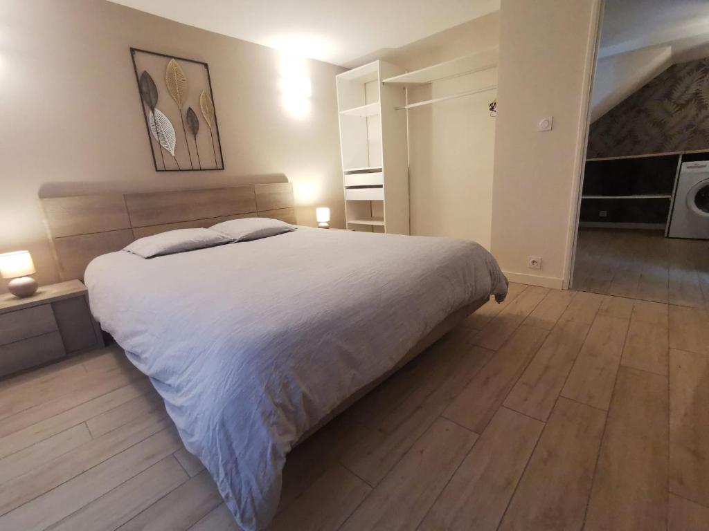 une chambre avec un grand lit blanc et du parquet dans l'établissement Appartement Cosy 2-4 personnes avec terrasse, à Marlens