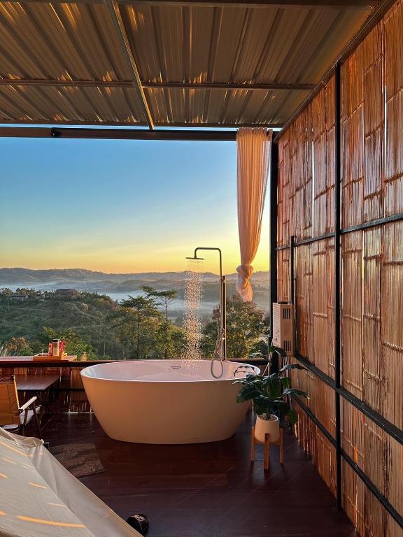 a bath tub in a bathroom with a large window at หรรษาวิว ที่พักเขาค้อ เพชรบูรณ์ in Khao Kho