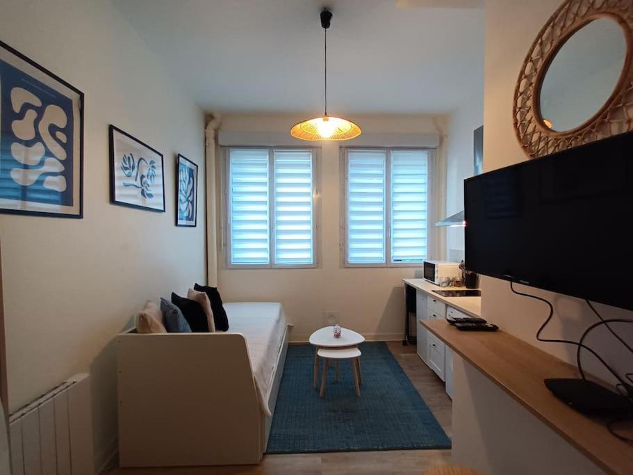 Cette chambre comprend un lit, une télévision et une table. dans l'établissement Le studio des Halles, au Havre