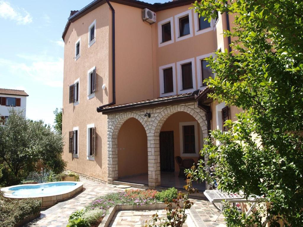 an external view of a house with a swimming pool at Ferienwohnung für zwei Personen in Fažana