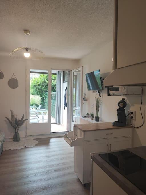 - une cuisine avec vue sur une salle à manger dans l'établissement studio cabine avec véranda et terrasse, à Luchon