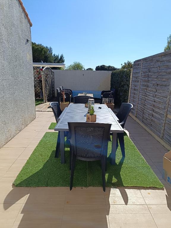 une table et des chaises assises sur une parcelle d'herbe dans l'établissement Les Mandrines, à Saint-Xandre