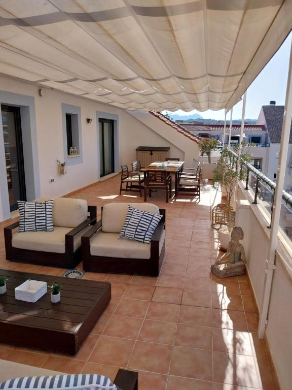 a patio with couches and tables on a balcony at ATICO MORAIRA in Moraira