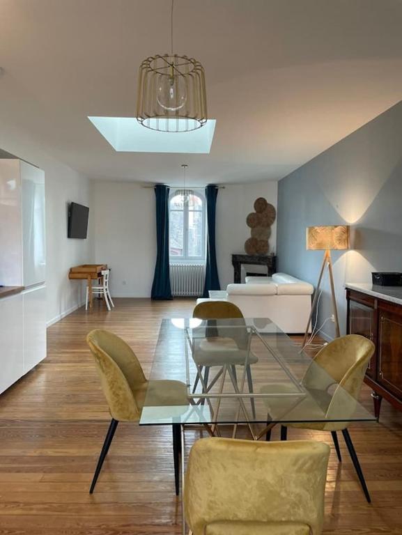 a living room with a glass table and chairs at CHTX Hôtel particulier Albert Ier in Châteauroux
