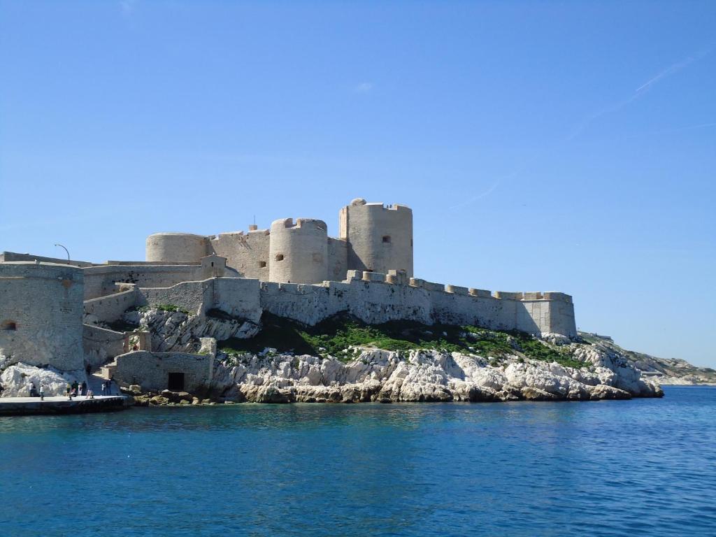 un château sur une île dans l'eau dans l'établissement Studio ILE DU FRIOUL, à Marseille