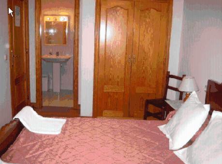 A bed or beds in a room at Hostal Pumar