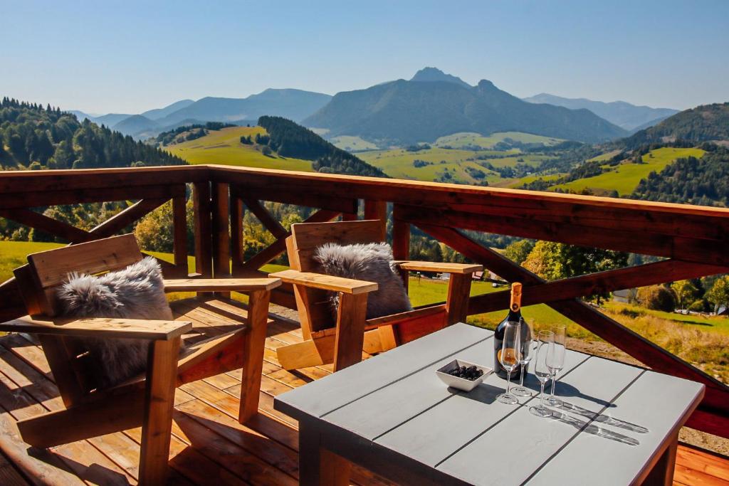 a table and chairs on a deck with a view of mountains at Chalet George in Zázrivá